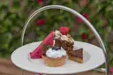 Small cakes and tarts on a tiered afternoon tea stand