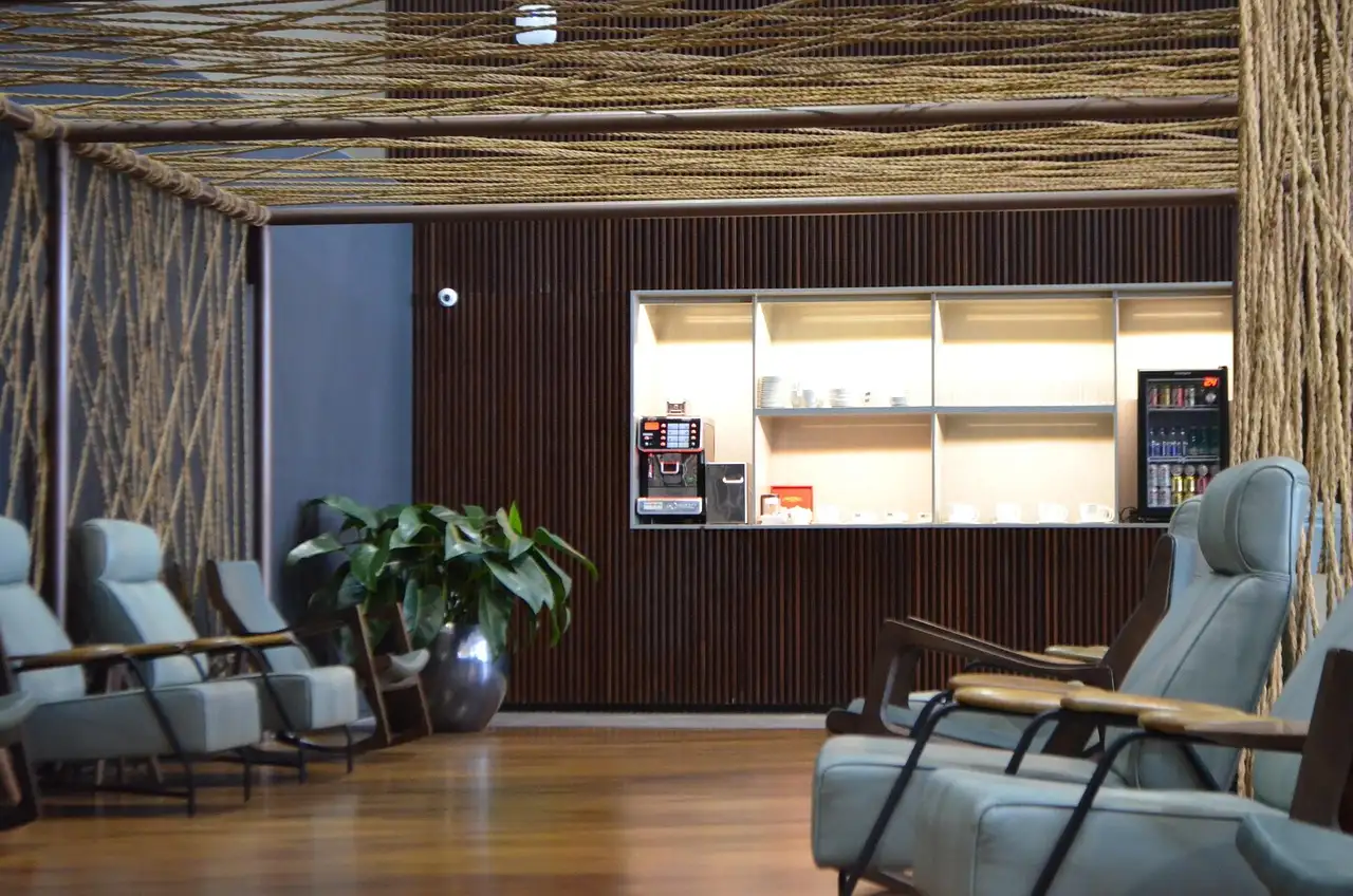 A quiet airport lounge with leather armchairs and a small coffee counter
