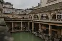 Green water of the Great Bath at the Roman Baths, ringed by stone columns
