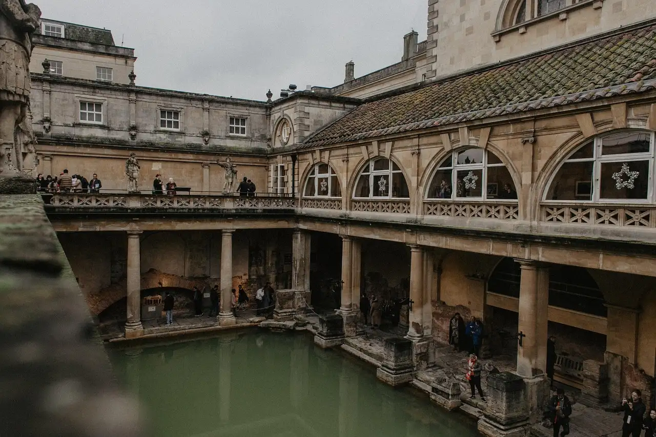 Green water of the Great Bath at the Roman Baths, ringed by stone columns