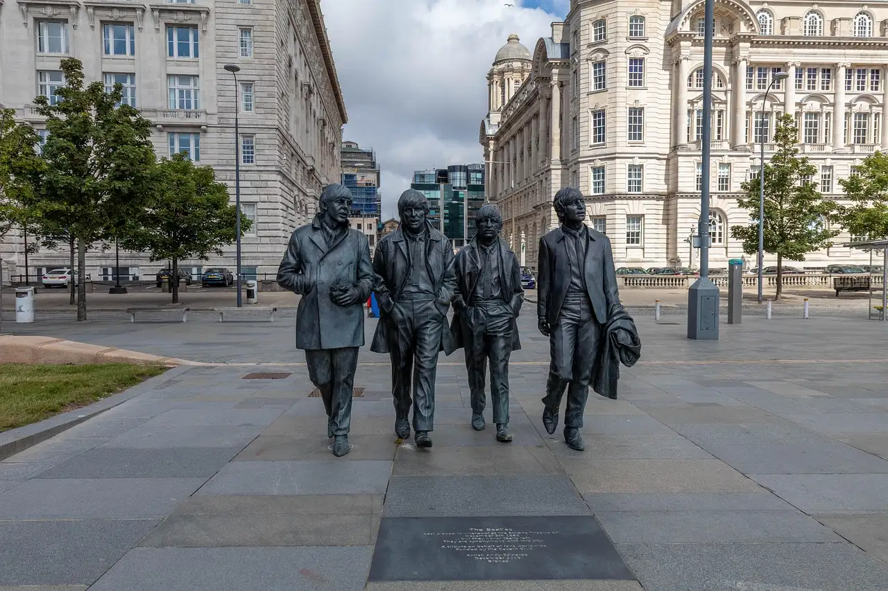 Beatles statue on Liverpool's waterfront with historic buildings behind