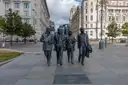Beatles statue on Liverpool's waterfront with historic buildings behind