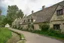 Old stone cottages of Arlington Row along a quiet lane in Bibury