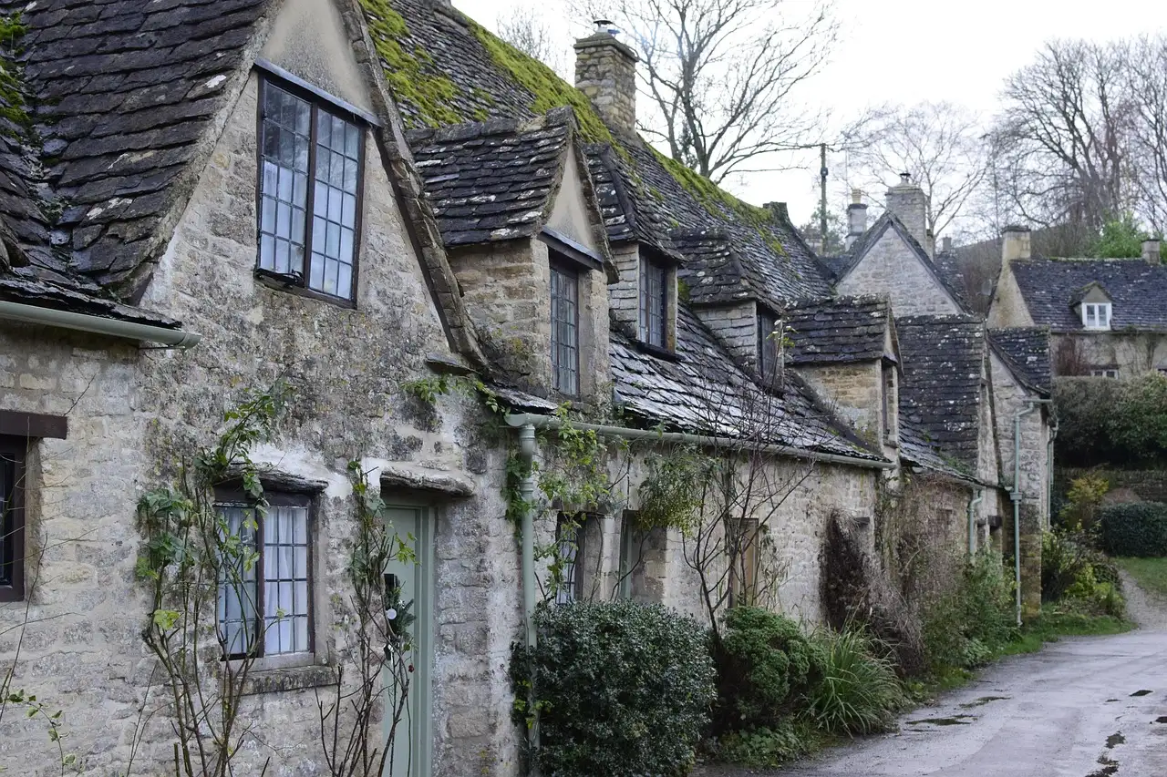 Stone cottages with climbing plants along a street in Bibury