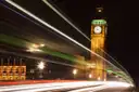 Big Ben lit up at night with light trails from passing traffic