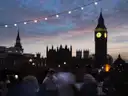 Big Ben and Parliament in silhouette at dusk, with a blurred crowd in front
