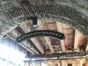 The Borough Market sign hanging under the brick railway arches
