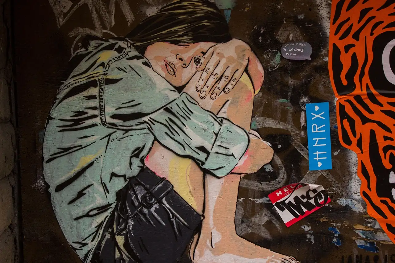 Painted street-art mural of a crouching figure on a London wall