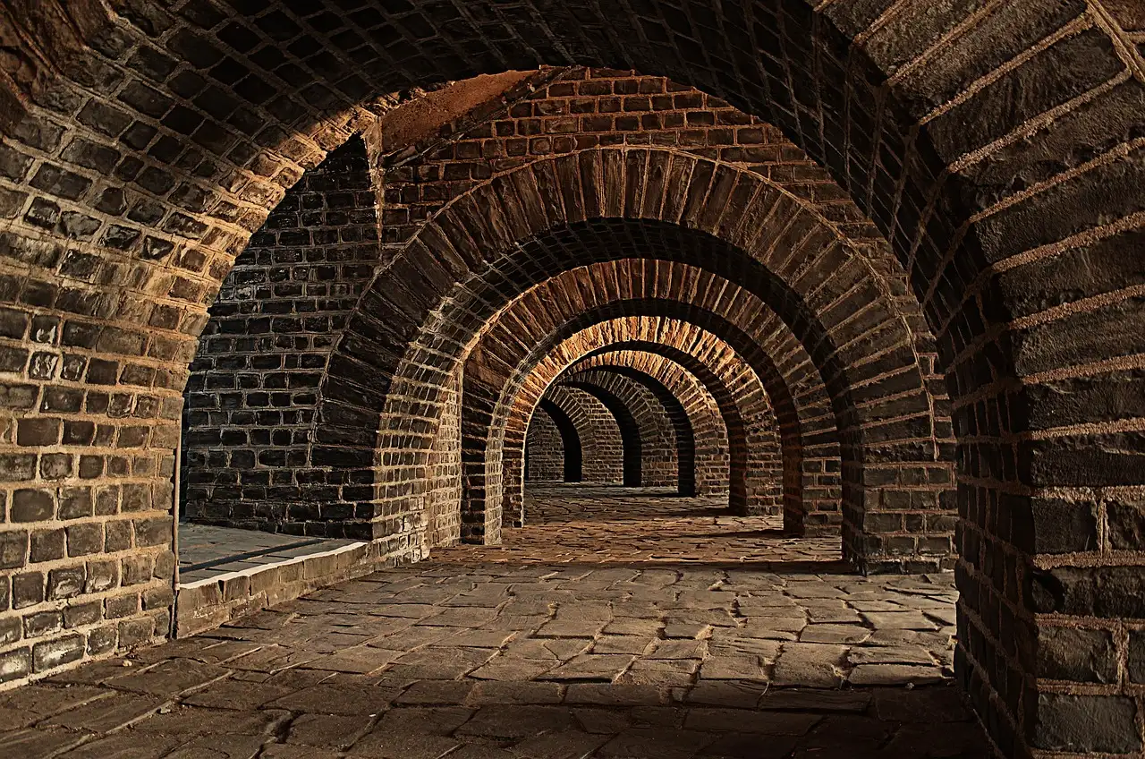 Brick vaulted arches receding into a dim underground passage