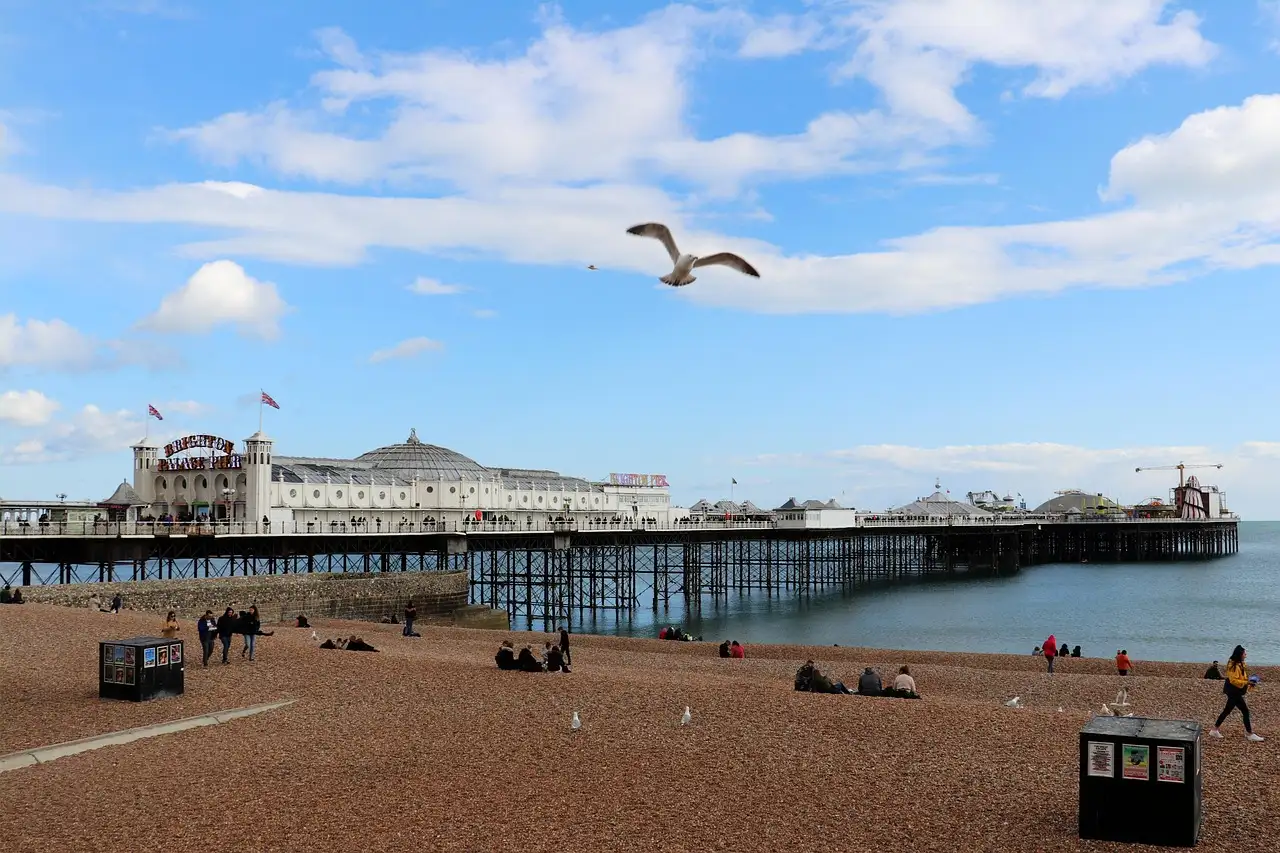 Brighton Palace Pier stretching out from the pebble beach under a blue sky