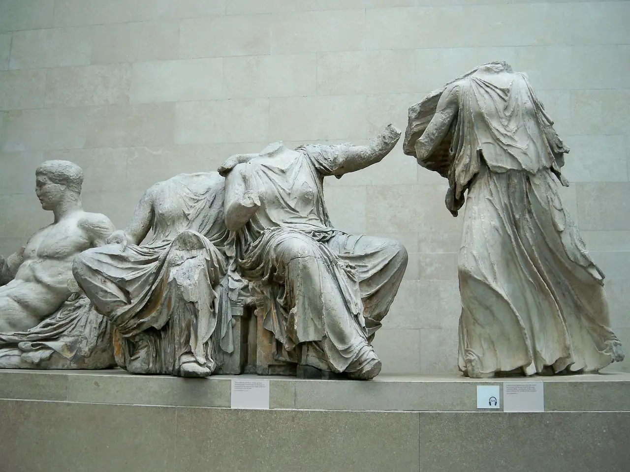 Headless marble figures from the Parthenon on display in a museum gallery