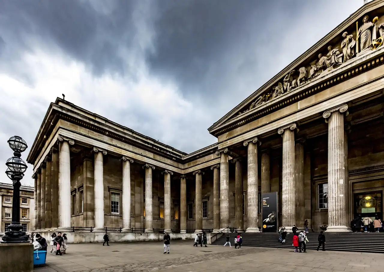 Columned portico of the British Museum under a stormy grey sky