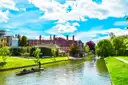 Punts on the River Cam beside green lawns and college buildings in Cambridge