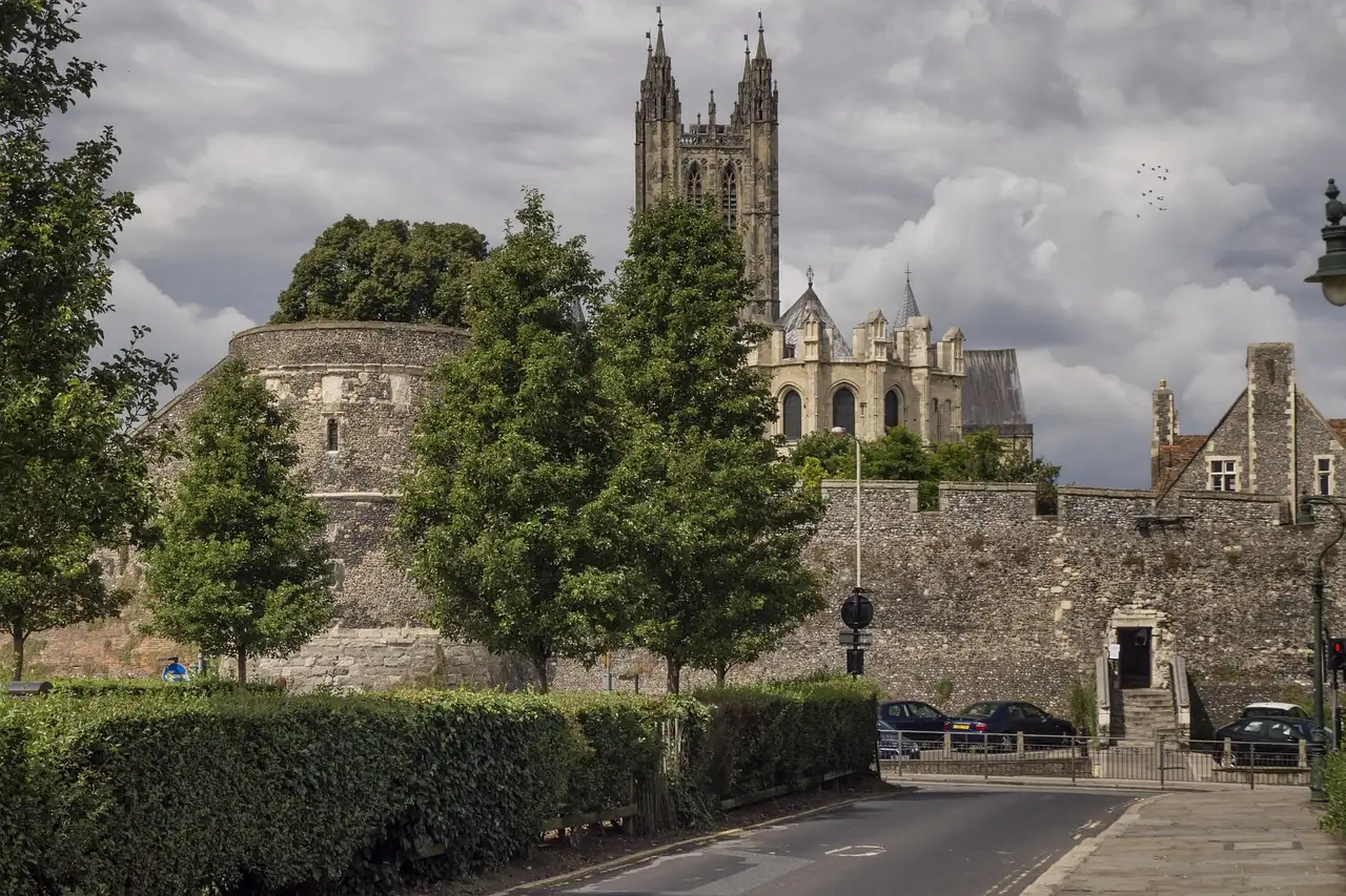 Canterbury's city wall with the cathedral tower rising behind trees