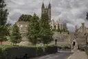Canterbury's city wall with the cathedral tower rising behind trees