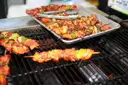Spiced chicken and vegetable skewers cooking on a grill