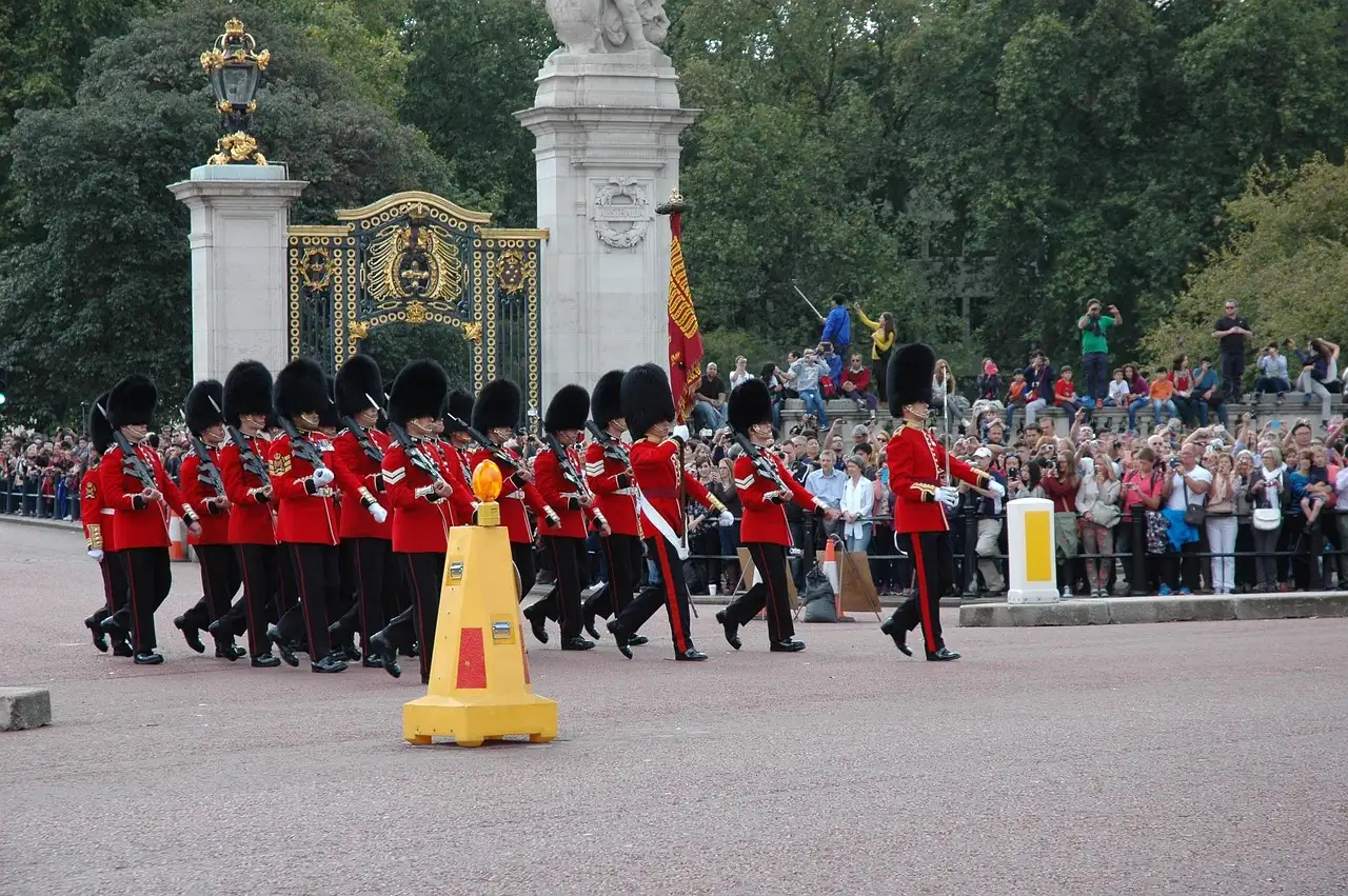 Guardsmen in red tunics and bearskin hats marching during the Changing of the Guard
