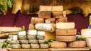 Wheels of cheese stacked on a market stall