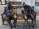 Bronze statues of Churchill and Roosevelt sitting together on a bench