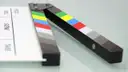 A film clapperboard with coloured stripes