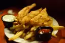 Battered fish and chips with tartare sauce and ketchup
