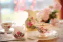 Flowered china teacups and a milk jug set out for afternoon tea