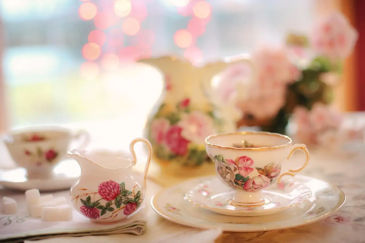 Flowered china teacups and a milk jug set out for afternoon tea