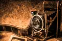 An old folding film camera with a strip of film negatives beside it
