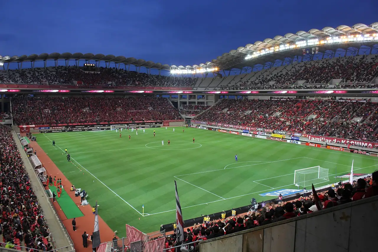 A football match at dusk in a full stadium