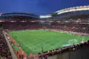 A football match at dusk in a full stadium