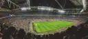 A packed football stadium under floodlights during a match