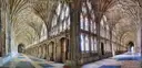 Fan-vaulted stone cloister of Gloucester Cathedral with stained glass windows