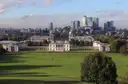 Greenwich Park's lawns sloping down to the Queen's House, with Canary Wharf behind