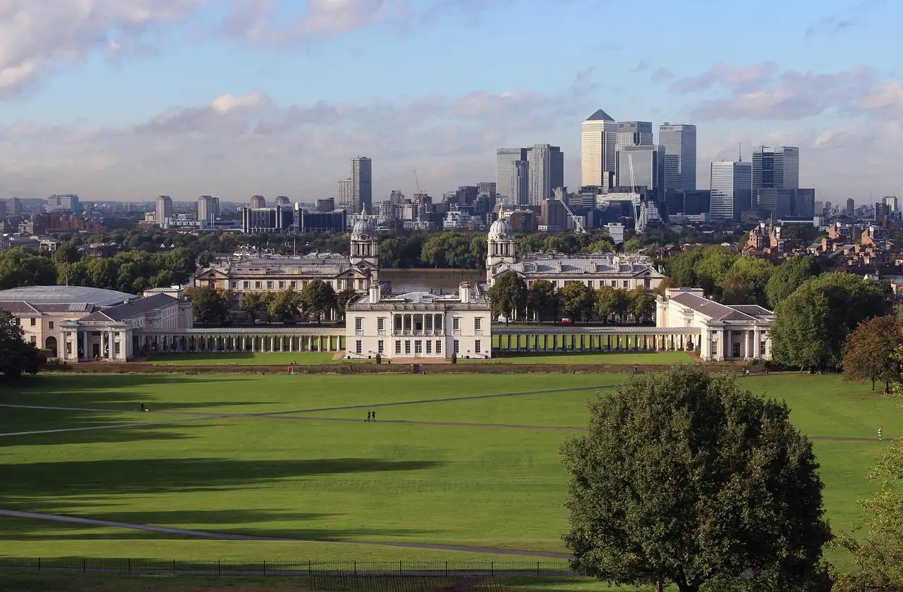 Greenwich Park's lawns sloping down to the Queen's House, with Canary Wharf behind