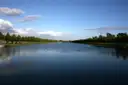 The tree-lined Long Water canal at Hampton Court under a blue sky