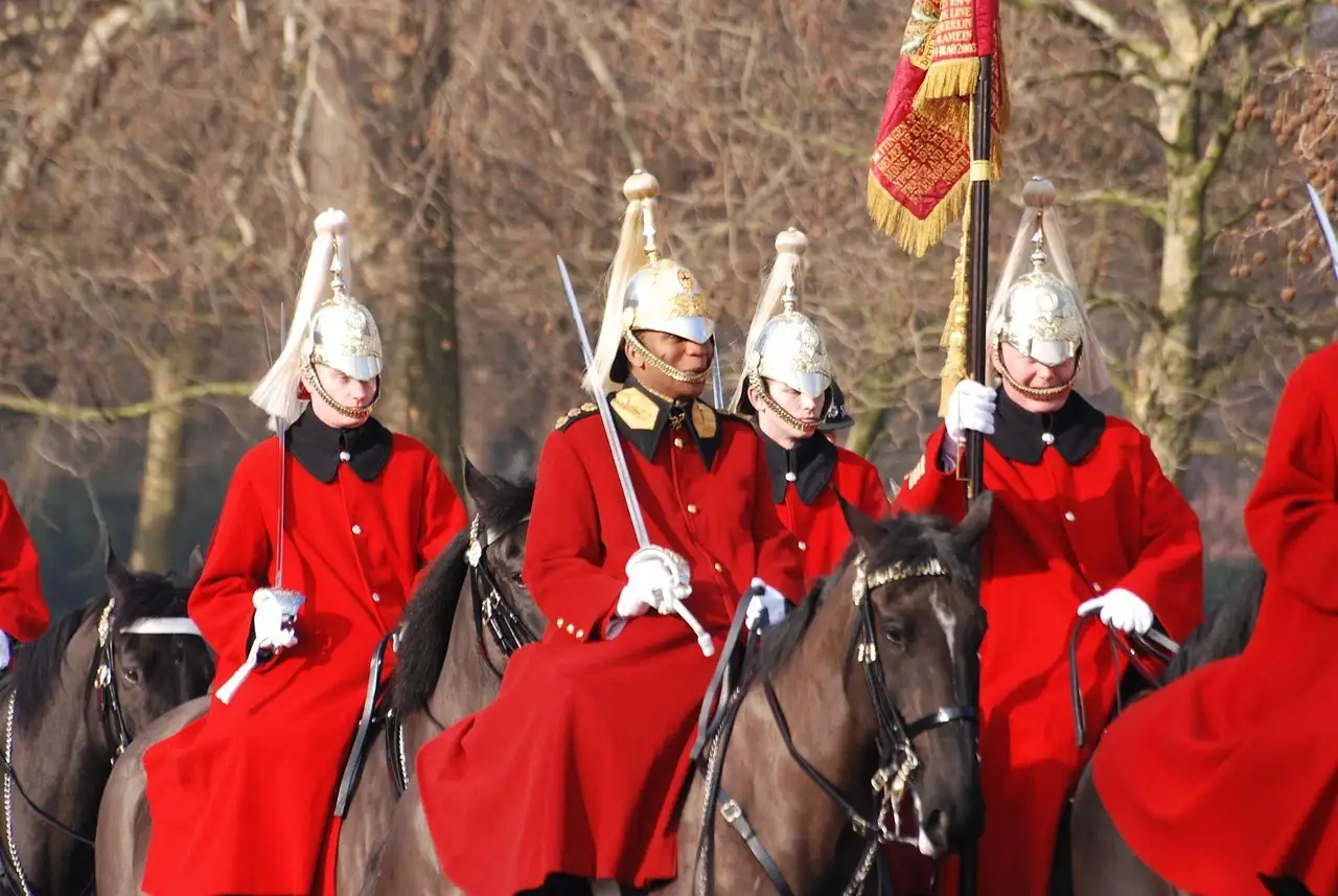 Household Cavalry troopers in red tunics and plumed helmets on horseback