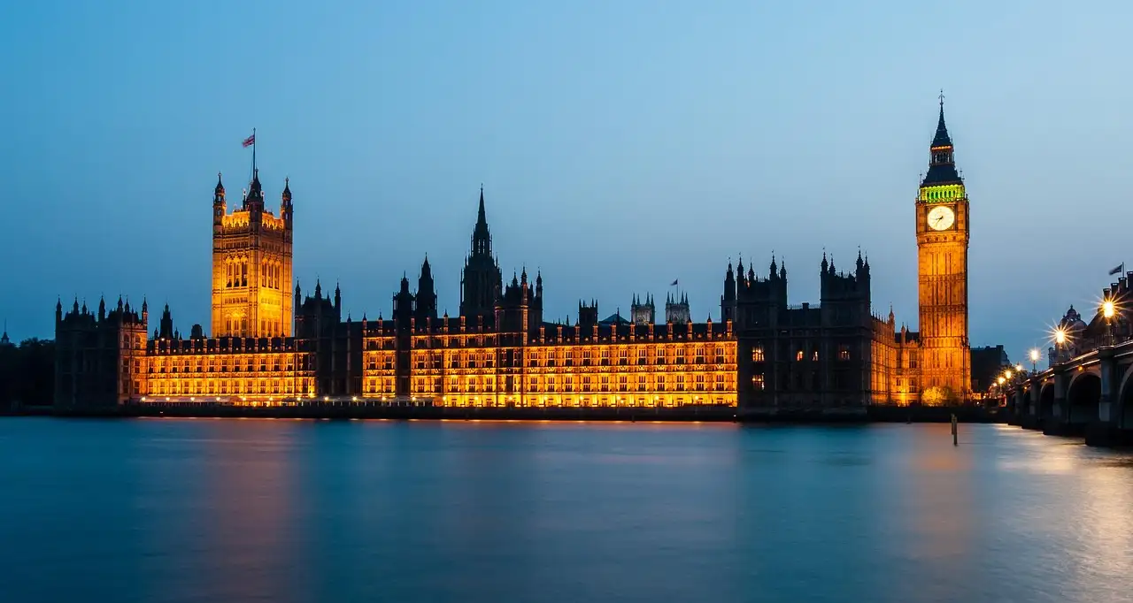 Houses of Parliament and Big Ben lit up at blue hour across the Thames