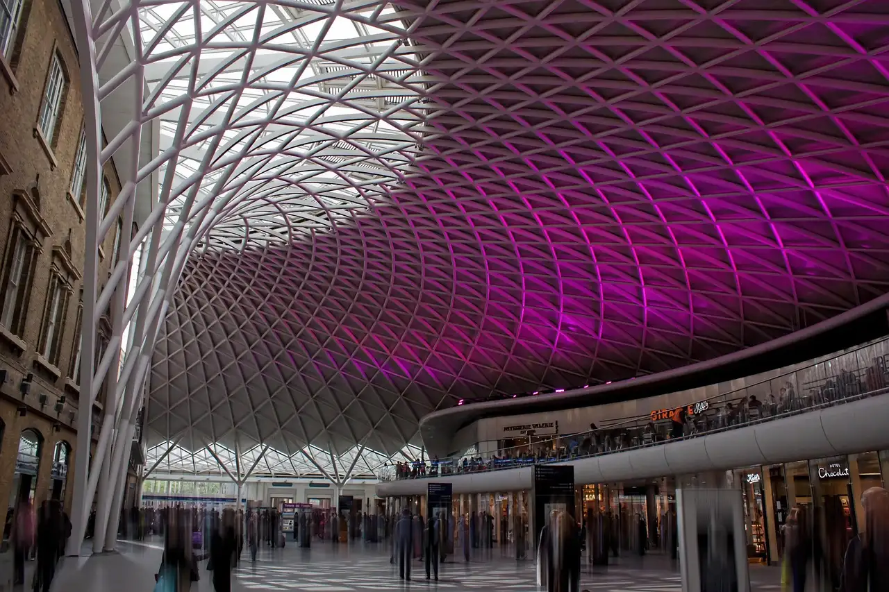 King's Cross station concourse with its lattice roof lit purple