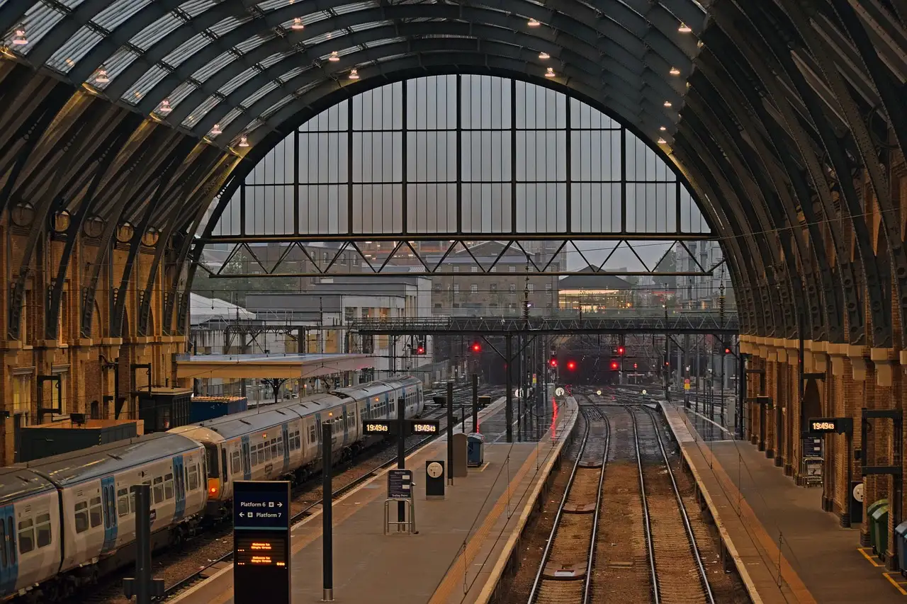 Platforms under the arched glass roof of King's Cross station with a train waiting
