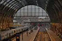 Platforms under the arched glass roof of King's Cross station with a train waiting