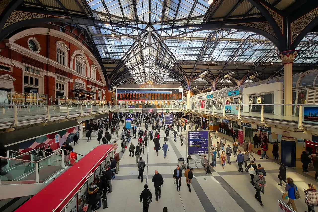 The busy concourse of a London railway station under an iron-and-glass roof