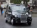 Front view of a black London taxi on a city street