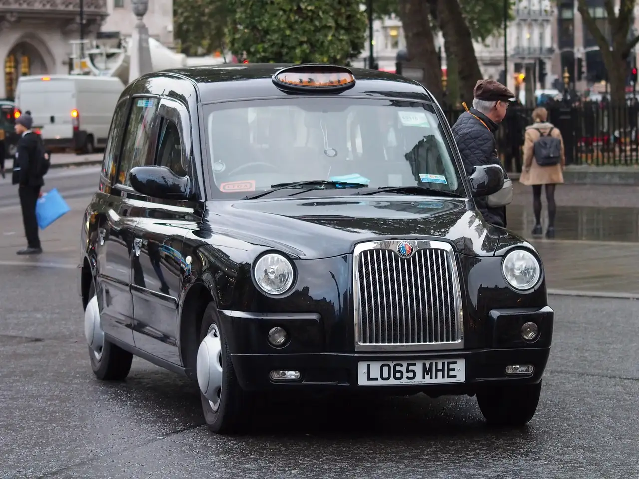Front view of a black London taxi on a city street