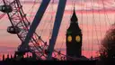 The London Eye and Big Ben in silhouette against a pink sunset sky