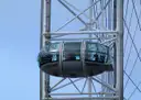A glass capsule on the London Eye against a blue sky