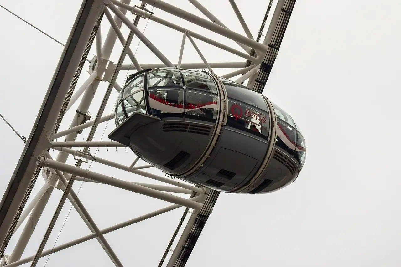 A London Eye capsule against a pale sky, framed by the wheel's white steel