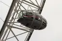 A London Eye capsule against a pale sky, framed by the wheel's white steel