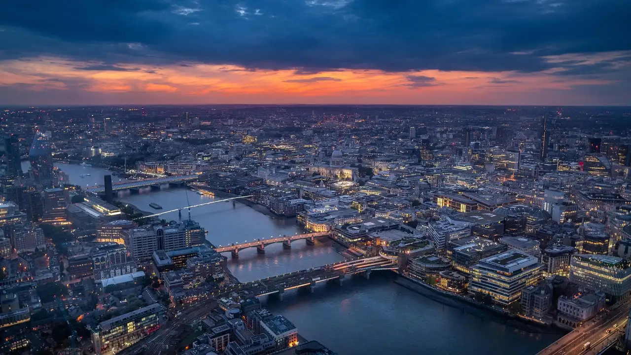London from high above at dusk, with the Thames and its bridges winding through the city