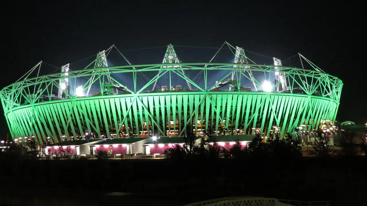 The London Olympic Stadium lit green at night