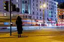 A London street at night, with traffic blurred into trails of light